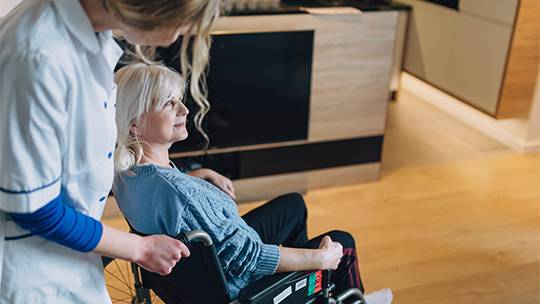 A caregiver assisting an individual with a laptop for NDIS support coordination Melbourne