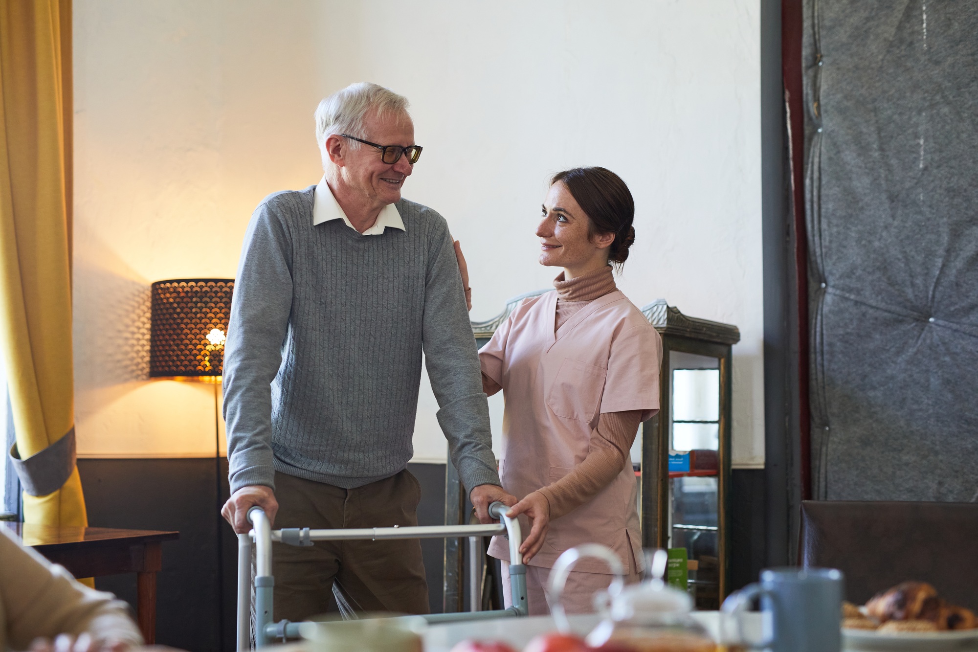 NDIS nurse assisting an elderly man with a walker, providing quality community at home in Melbourne."