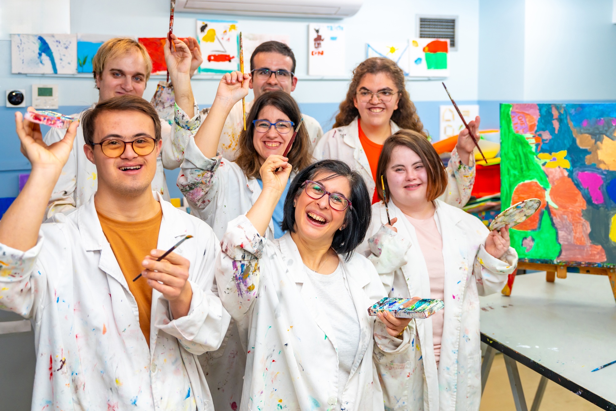 A group of happy individuals with disabilities painting together in an art class, supported ndis provider melbourn